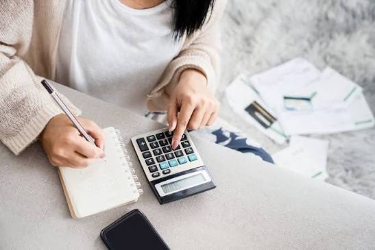 How to Create a Personal Budget That Actually Works Person creating a personal budget with a laptop and calculator