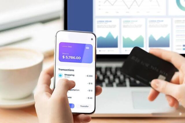 Smartphone banking app next to a bank card and financial documents Bank account comparison using a smartphone banking app